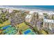 An aerial view features condo buildings beside the beach, featuring tennis courts and manicured lawns at 139 S Dunes Dr. # 304, Pawleys Island, SC 29585