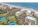 This aerial shot showcases condo buildings by the ocean, along with manicured lawns and tennis courts at 139 S Dunes Dr. # 304, Pawleys Island, SC 29585