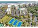 An aerial view showcases the beachfront condo community with tennis courts and lush landscaping at 139 S Dunes Dr. # 304, Pawleys Island, SC 29585