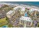 An overhead view reveals condo buildings near the beach, complete with palm trees and a pool at 139 S Dunes Dr. # 304, Pawleys Island, SC 29585