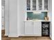 Wet bar featuring custom backsplash, glass door cabinetry, and beverage refrigerator at 139 S Dunes Dr. # 304, Pawleys Island, SC 29585