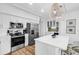 Modern white kitchen with stainless steel appliances, wood floors, and an open layout at 139 S Dunes Dr. # 304, Pawleys Island, SC 29585