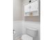 Bathroom features a toilet, white wainscoting, and a white storage cabinet with a shelf at 1459 Villena Dr., Myrtle Beach, SC 29579