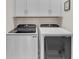 Modern laundry room equipped with Samsung washer, dryer, and white cabinets for storage at 1459 Villena Dr., Myrtle Beach, SC 29579