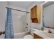 Bathroom with shower-tub combination with blue shower curtain plus wood cabinetry and a sink at 1836 Juniper Dr., Conway, SC 29527
