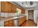 Bright kitchen featuring oak cabinetry, stainless dishwasher and ample counter space with views out the window at 1836 Juniper Dr., Conway, SC 29527