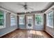 Bright sunroom features multiple windows, a ceiling fan, and wood-look floors at 1836 Juniper Dr., Conway, SC 29527