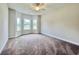 Bedroom with a bay of large windows and neutral colored carpet and walls at 189 Norris Ln, Loris, SC 29569
