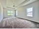 A spacious bedroom with tray ceilings, a ceiling fan, and large windows at 189 Norris Ln, Loris, SC 29569