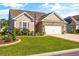 Beautiful home showcasing lush green grass, flower beds, brick-lined driveway, and an attached two-car garage at 1941 La Playa Dr., Myrtle Beach, SC 29588