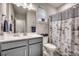 Neutral bathroom with gray cabinetry, a mirror, and patterned shower curtain at 2023 Singing Palm Loop, Little River, SC 29566