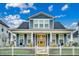 Charming two-story home with a welcoming front porch, white picket fence and a beautifully landscaped yard at 2023 Singing Palm Loop, Little River, SC 29566