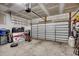 Spacious garage featuring a large garage door, high ceilings, and ample storage space with various stored items at 2023 Singing Palm Loop, Little River, SC 29566