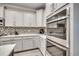 Well-appointed kitchen featuring stainless appliances, stylish tile backsplash, and a double oven at 2023 Singing Palm Loop, Little River, SC 29566