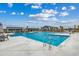 Large community swimming pool with inviting blue water, surrounded by lounge chairs, palm trees, and clubhouse at 2023 Singing Palm Loop, Little River, SC 29566