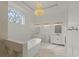 Bright and luxurious bathroom includes dual vanities, a soaking tub, and a chandelier at 212 78Th Ave. N, Myrtle Beach, SC 29572