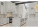 Bright kitchen boasts white cabinetry, stainless steel appliances, an island, and quartz countertops at 212 78Th Ave. N, Myrtle Beach, SC 29572