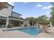 Backyard view of a modern home and a pool surrounded by palm trees and a cabana at 212 78Th Ave. N, Myrtle Beach, SC 29572