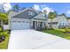 Long driveway with a decorative palm tree mosaic leading to a home with grey siding and a manicured lawn at 212 Starlit Way, Myrtle Beach, SC 29579