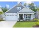 Attractive house with a manicured lawn, a welcoming front porch with seating, and a two-car garage at 212 Starlit Way, Myrtle Beach, SC 29579
