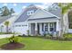 Charming home with a two-car garage, stone accents, manicured lawn, and a cozy front porch with seating at 212 Starlit Way, Myrtle Beach, SC 29579