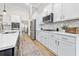 Kitchen boasts stainless appliances, white cabinetry, herringbone backsplash and quartz countertops at 212 Starlit Way, Myrtle Beach, SC 29579