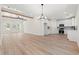 Open-concept living room featuring a kitchen, ceiling beams, chandelier, and wood-look flooring at 2426 Park St., North Myrtle Beach, SC 29582