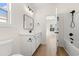 Well-lit bathroom features sleek black hardware, a white vanity, and a shower/tub combo with wood-look floors at 2428 Park St., North Myrtle Beach, SC 29582