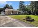 Cozy brick home with a metal roof, a driveway, and mature trees in a serene setting at 320 Edgewood Circle, Conway, SC 29527