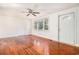 Bright living room with gleaming hardwood floors, a ceiling fan, and a large window at 320 Edgewood Circle, Conway, SC 29527