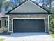 Attached garage door with stone accents and windows providing ample lighting at 3216 Hugo Rd., Conway, SC 29527