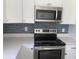 Stainless steel appliances, quartz countertop, and stylish backsplash in the kitchen at 3216 Hugo Rd., Conway, SC 29527