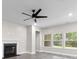 Bright living room boasts a fireplace, lots of natural light, and a modern ceiling fan at 3217 Shadow Pine Ct., Myrtle Beach, SC 29579