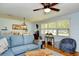 Bright living room features a blue sofa, ceiling fan, and large windows at 3602 Magnolia St. # 3602, Myrtle Beach, SC 29577