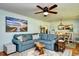 Comfortable living room featuring a blue sofa, ceiling fan, and beach-themed artwork at 3602 Magnolia St. # 3602, Myrtle Beach, SC 29577