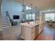 Open-concept living space featuring a modern kitchen island, adjoining staircase, and cozy living room at 376 Mikita Dr., Surfside Beach, SC 29575