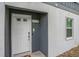 Exterior shot of the white front door of unit #5 with door sign, keypad entry and window at 403 71St Ave. N # 5, Myrtle Beach, SC 29572