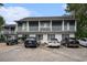 Two story condo building featuring white facade, upper level balconies, and ample parking in front at 403 71St Ave. N # 5, Myrtle Beach, SC 29572