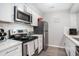 Well-equipped kitchen with stainless steel appliances, white cabinetry and tile backsplash at 403 71St Ave. N # 5, Myrtle Beach, SC 29572