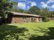Brick home exterior with a lush green lawn and mature trees in the backyard at 4041 Long Line Ln., Myrtle Beach, SC 29579