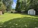 Spacious backyard with green lawn, mature trees, and storage shed, ideal for outdoor activities at 4041 Long Line Ln., Myrtle Beach, SC 29579