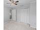 Bedroom boasts neutral walls and carpet, with a ceiling fan, and ample closet space at 4115 Little River Rd. # 1-E, Myrtle Beach, SC 29577