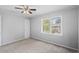Cozy bedroom featuring neutral carpet, ceiling fan, and large window overlooking the backyard at 4115 Little River Rd. # 1-E, Myrtle Beach, SC 29577