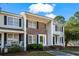 A lovely townhouse with a brick and vinyl exterior, under a blue sky, featuring shaded entrances and a well-kept lawn at 4115 Little River Rd. # 1-E, Myrtle Beach, SC 29577