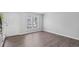 Bright, empty room with wood floors and a window, perfect for customization, offering a blank canvas for the new owner at 4115 Little River Rd. # 1-E, Myrtle Beach, SC 29577