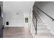 Bright living room featuring wood floors, neutral paint, a carpeted staircase, and natural light streaming through the doorway at 4115 Little River Rd. # 1-E, Myrtle Beach, SC 29577
