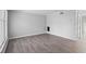 A bright, empty room featuring modern wood-look flooring, a large window, and neutral paint, offering a versatile living space at 4115 Little River Rd. # 1-E, Myrtle Beach, SC 29577