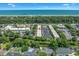 Community aerial view of condos with a parking area, mature trees, and waterway leading to ocean at 4701 N Kings Hwy. # 8, Myrtle Beach, SC 29577