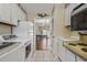Cozy kitchen features white appliances, tile flooring, and a peek into the dining area at 4701 N Kings Hwy. # 8, Myrtle Beach, SC 29577
