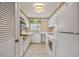 Functional galley kitchen with white cabinets, appliances, and ample countertop space at 4701 N Kings Hwy. # 8, Myrtle Beach, SC 29577
